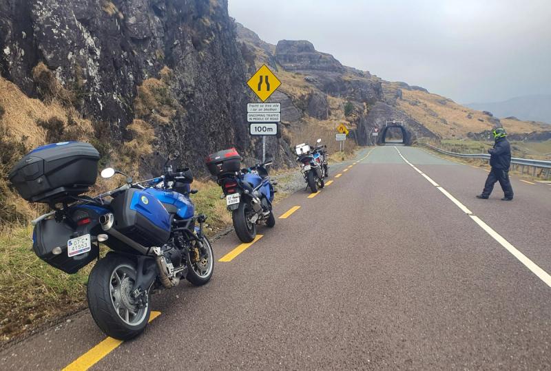 Motorcycles parked at the roadside before the Caha Pass rock tunnel on the Beara Peninsula