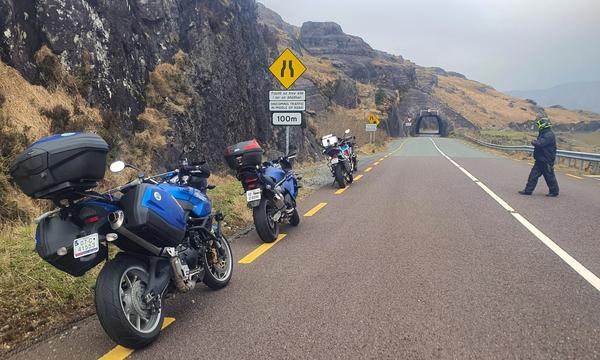 Motorcycles pulled in before the rock tunnels on the Caha Pass