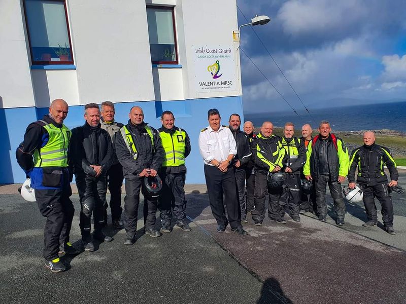 Tour group with a Coast Guard officer outside the Valentia Island Coast Guard station