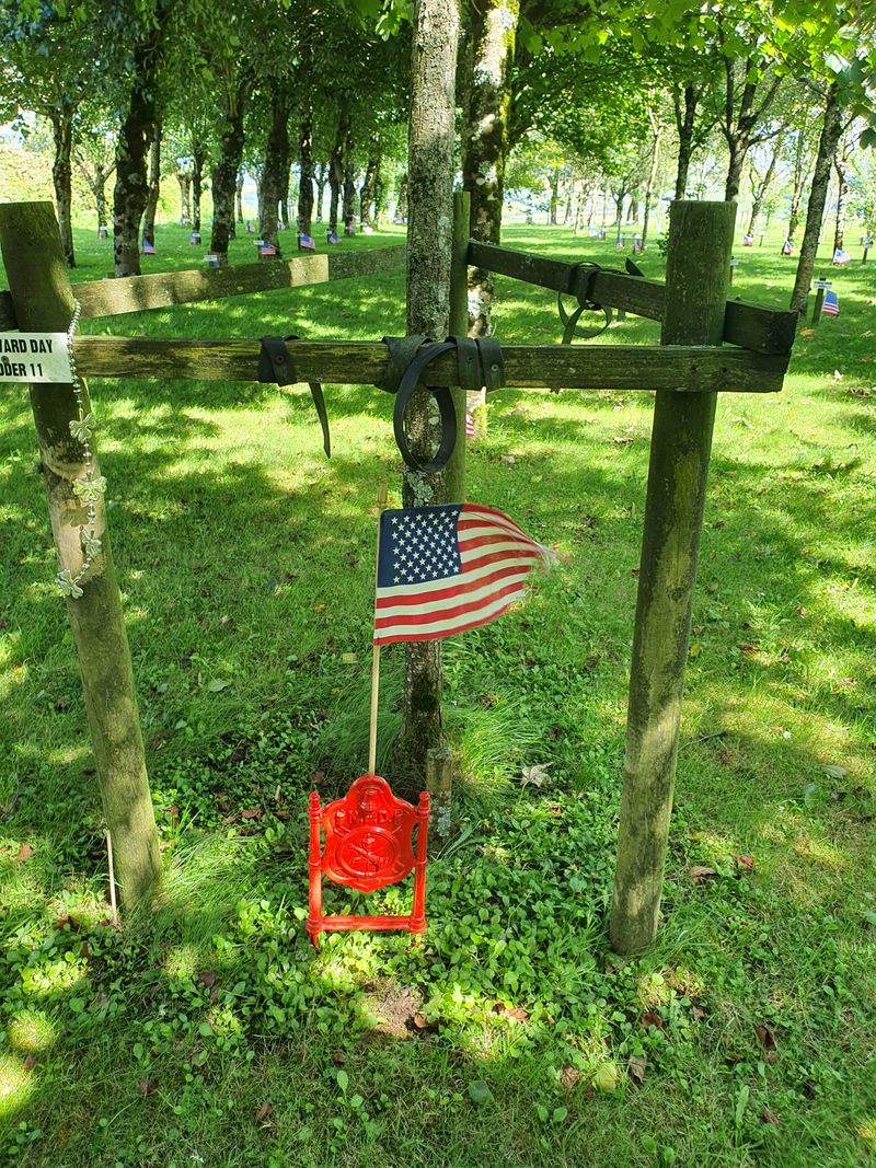 American flag and FDNY plaque at a firefighter's memorial tree in the Ringfinnan Garden of Remembrance, Kinsale