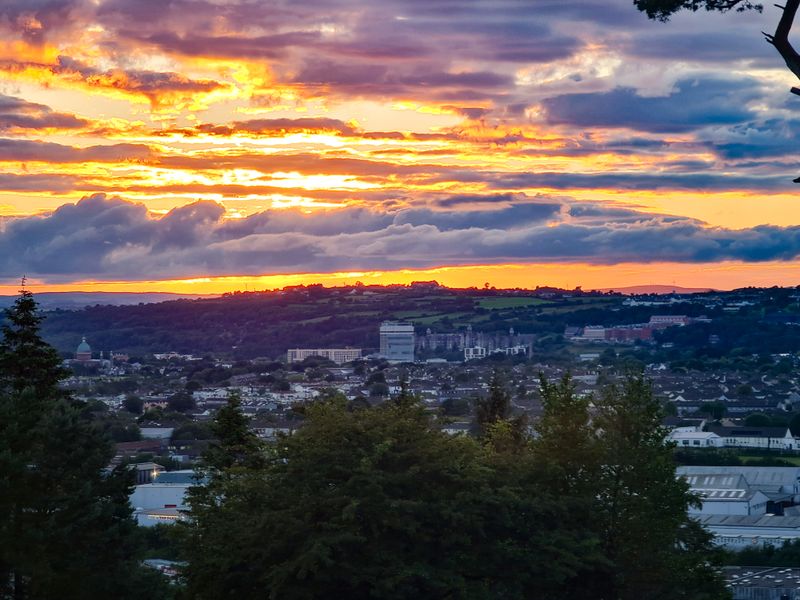 Fiery sunset sky over Cork city with hills on the horizon
