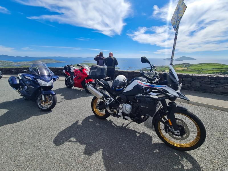 Three touring motorcycles parked at a Ring of Kerry viewpoint overlooking Derrynane Bay