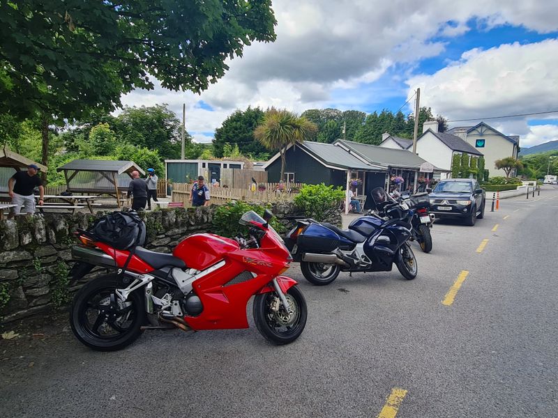 Motorcycles parked outside a rural Irish village café during a tour coffee stop