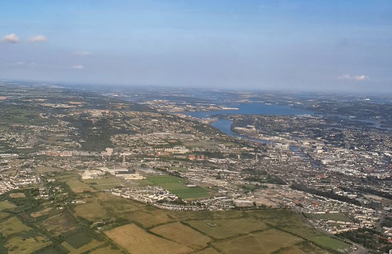 Wide hazy aerial view of Cork city and its harbour stretching to the sea