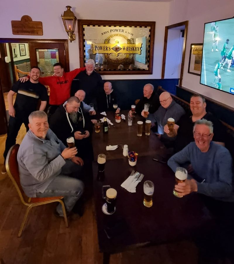 Motorcycle tour group sharing pints in a traditional Irish pub after a day's riding