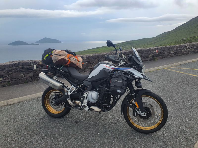 Motorcycle loaded with camping gear at the Coomakista Pass viewpoint overlooking islands off the Ring of Kerry