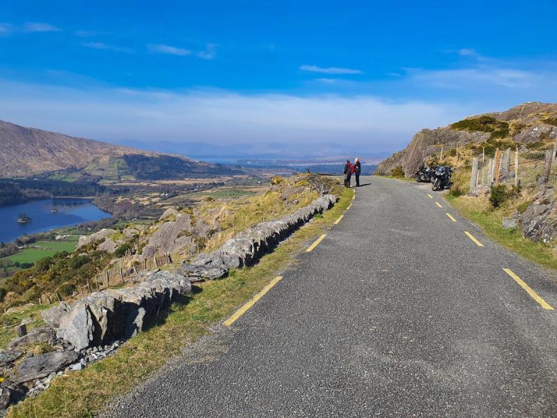 Motorcycles and riders paused at a Healy Pass viewpoint overlooking Glanmore Lake on the Beara Peninsula