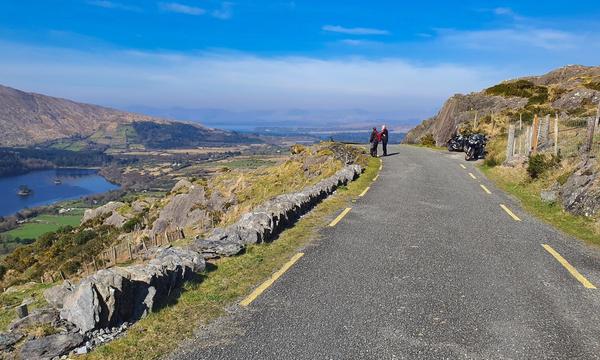 Riders take in the view over Glanmore Lake at the top of the Healy Pass