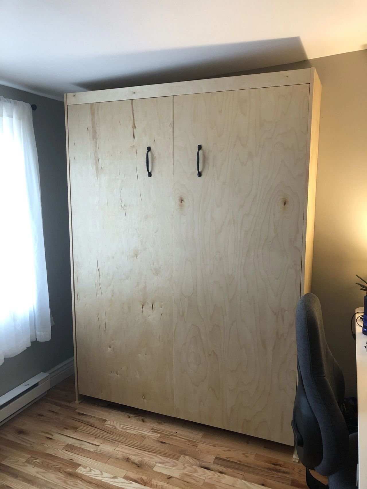 Murphy bed cabinet closed, with black handles