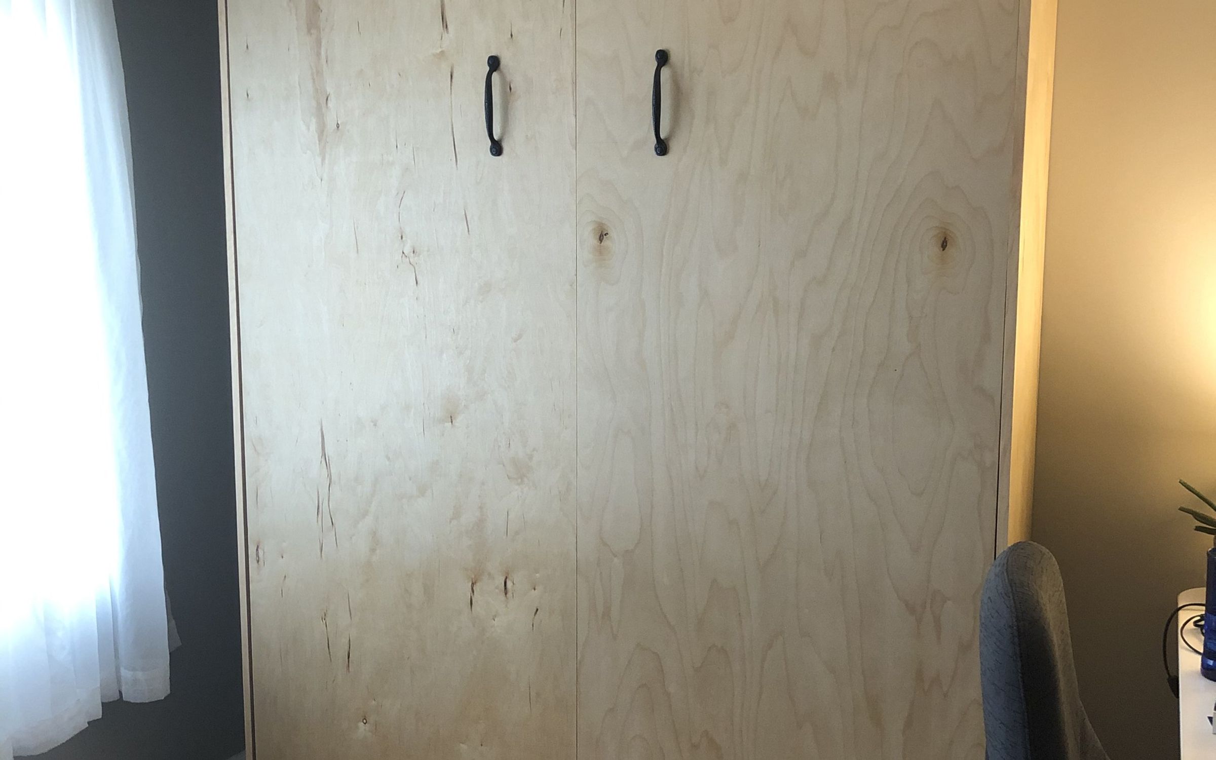 Murphy bed cabinet closed, with black handles