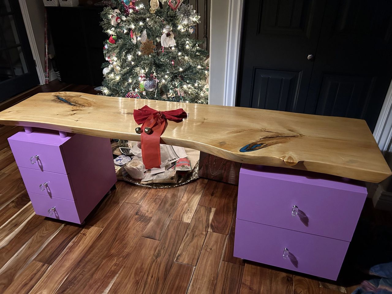 Live-edge wood slab desk on two purple drawer pedestals, plywood drawers