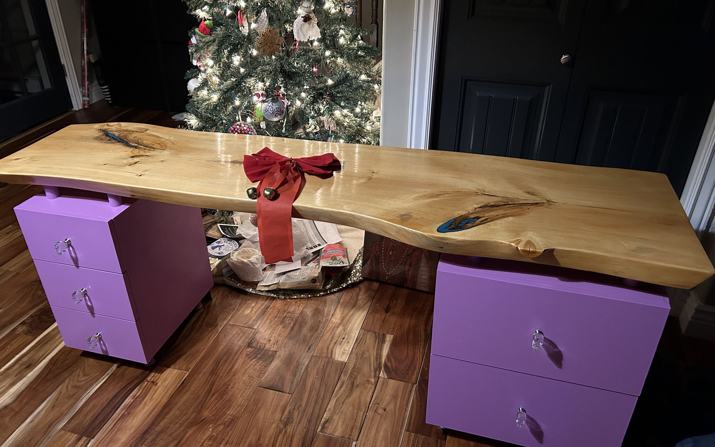 Live-edge wood slab desk on two purple drawer pedestals, plywood drawers