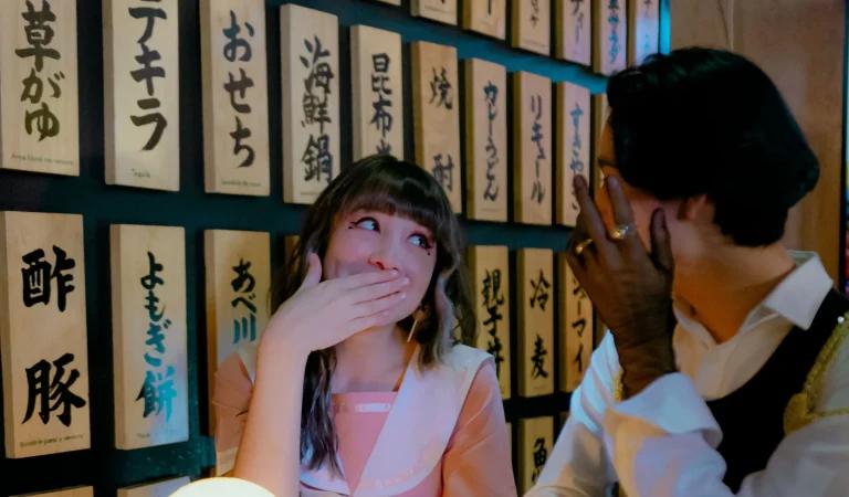 A woman hiding a smile behind her hand, keeping something just for herself