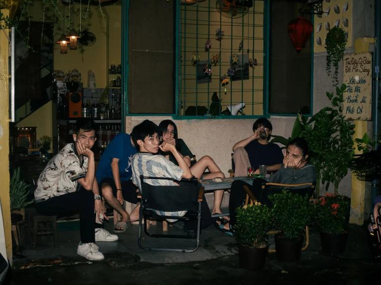 Friends gathered around a courtyard table at night, an evening that belongs to the people who were there