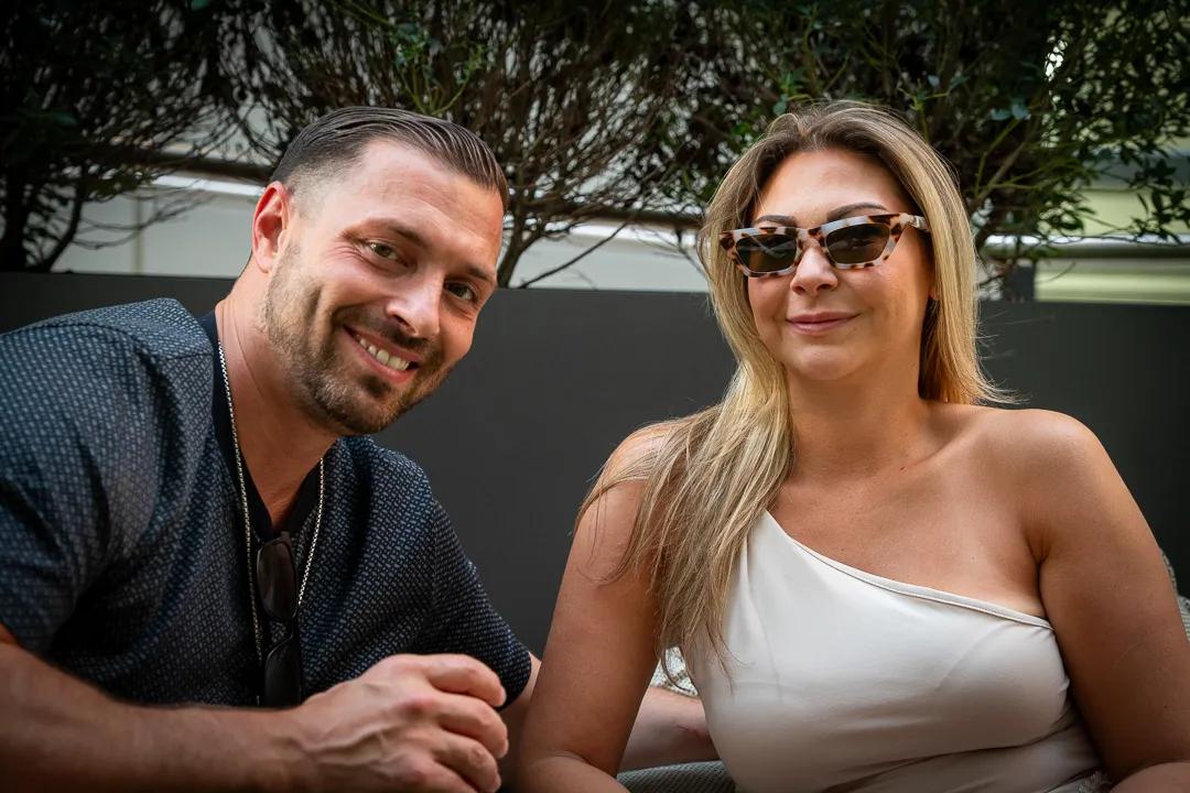 Two guests smiling at a table on the roof deck