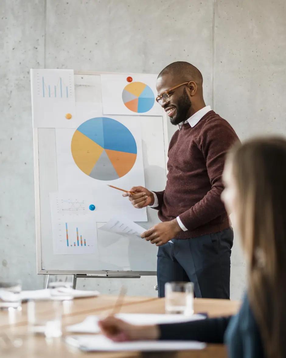 Un consultant commente un graphique circulaire devant une équipe réunie.