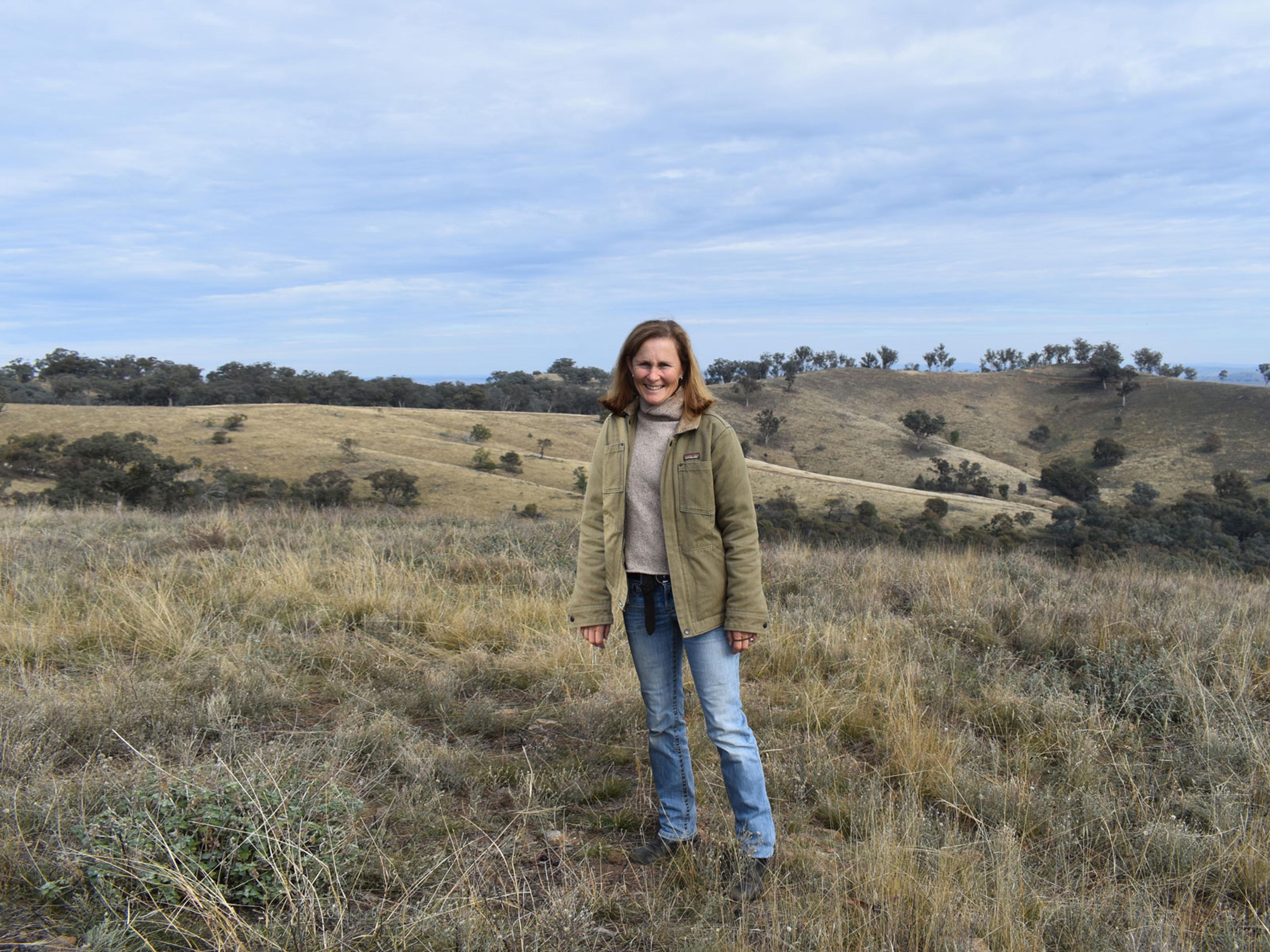 A person standing in the middle of her farm.