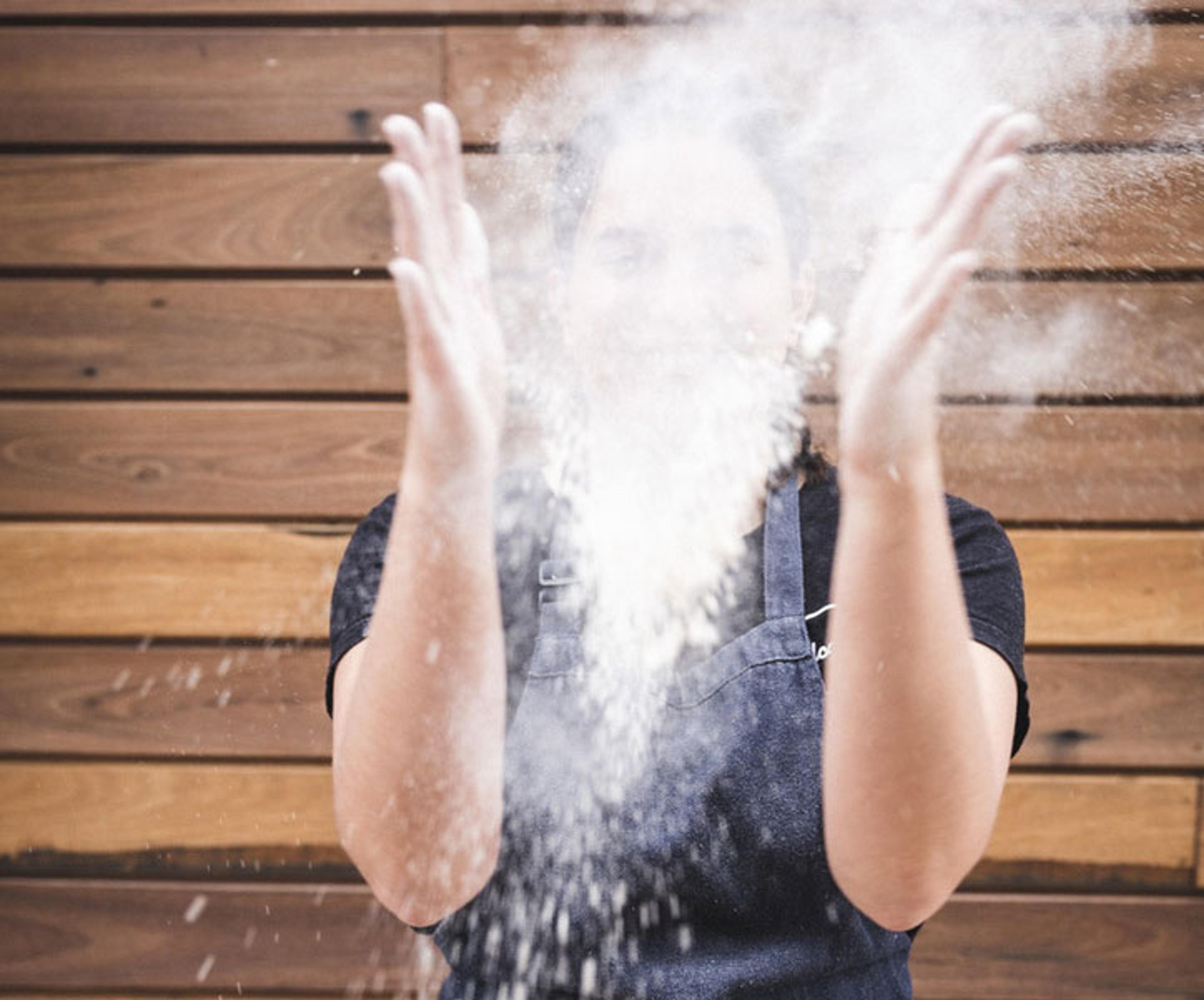 A person who has just thrown up a handful of flour and it has exploded in front of her face.