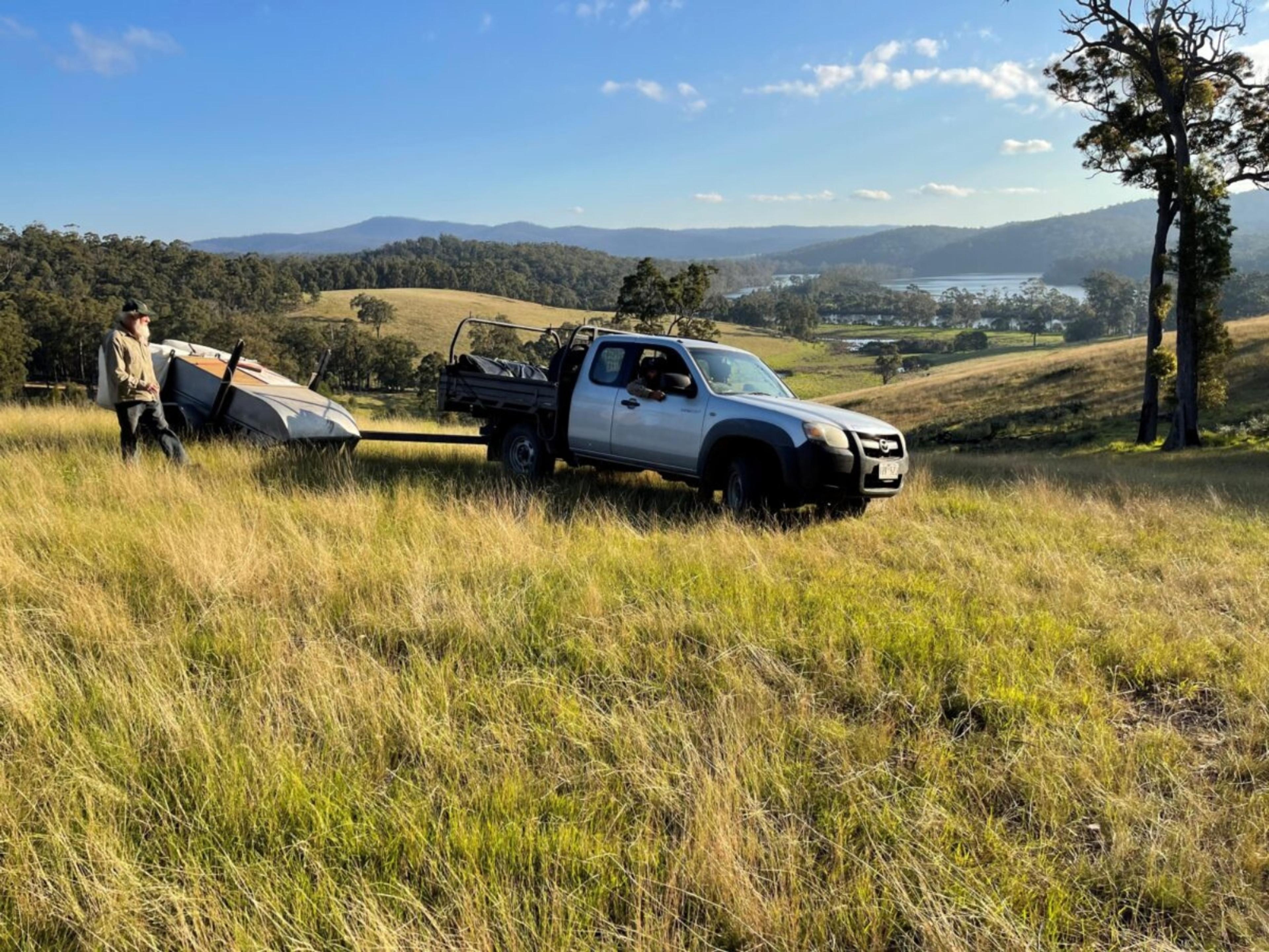 A ute in a paddock on a sunny day.