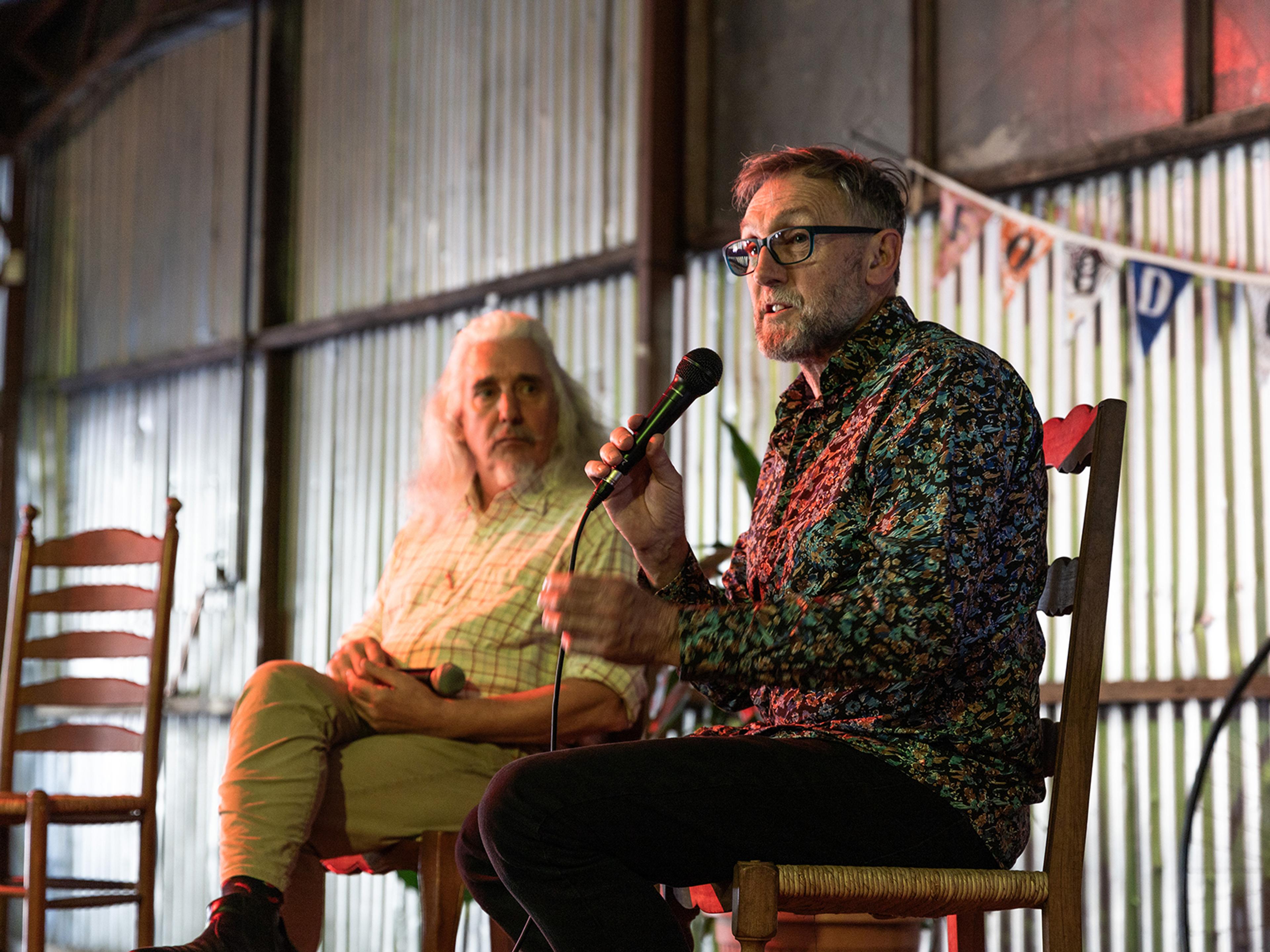 Two people on stage speaking at an event in the Food Connect Shed.