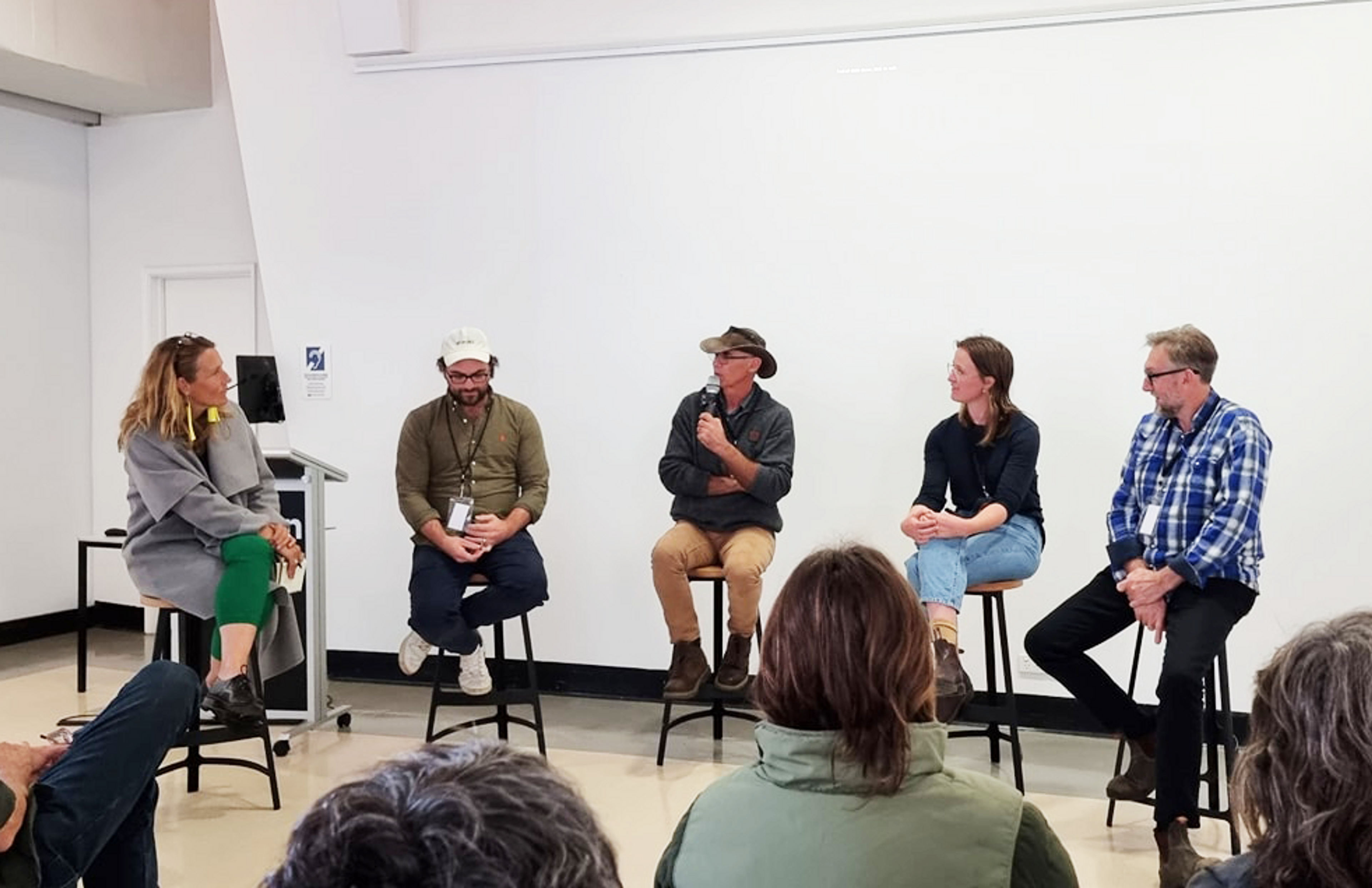 Five people sitting on stools in a white room talking about regenerative agriculture
