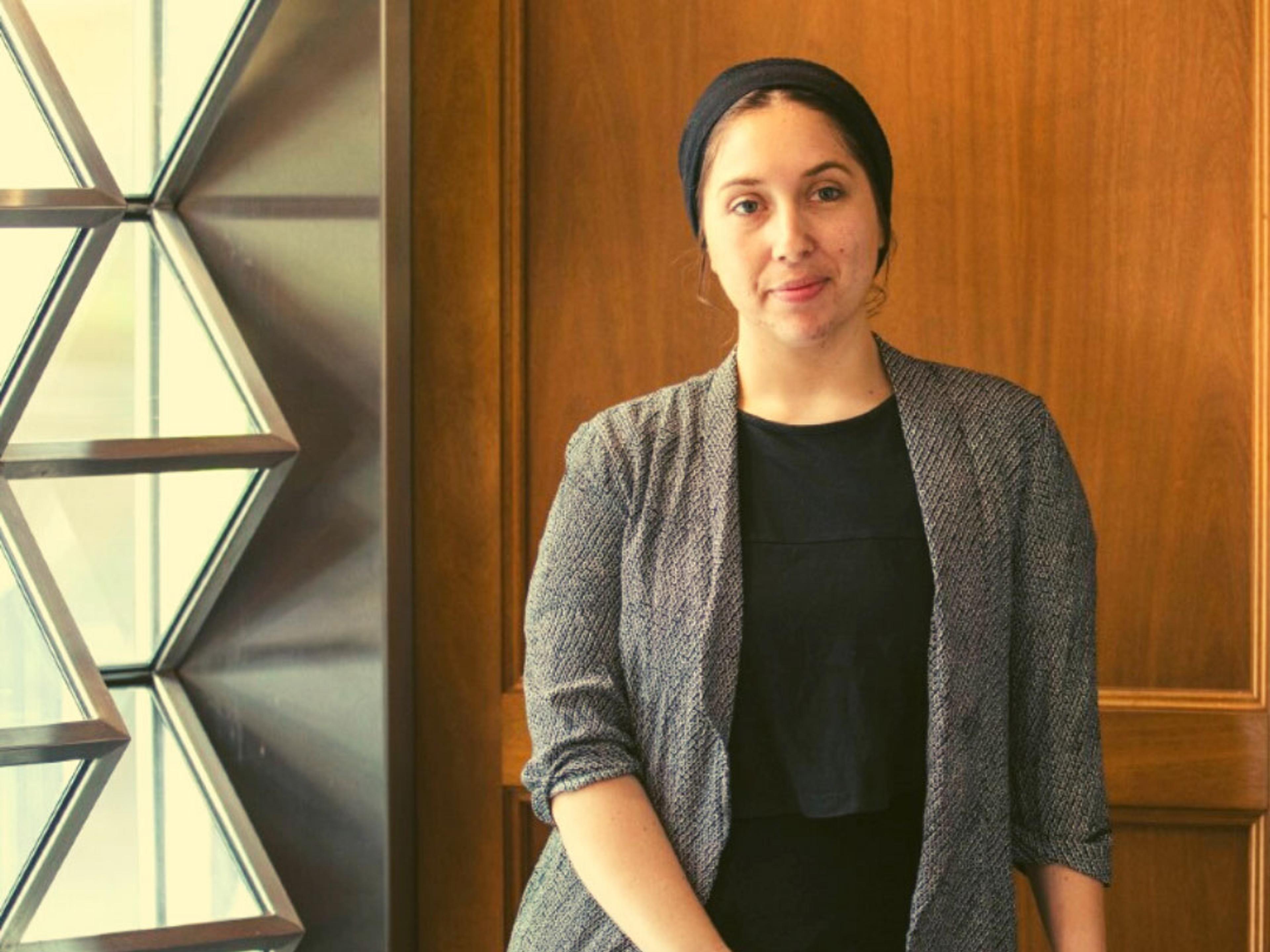 A person standing in front of a wooden wall.
