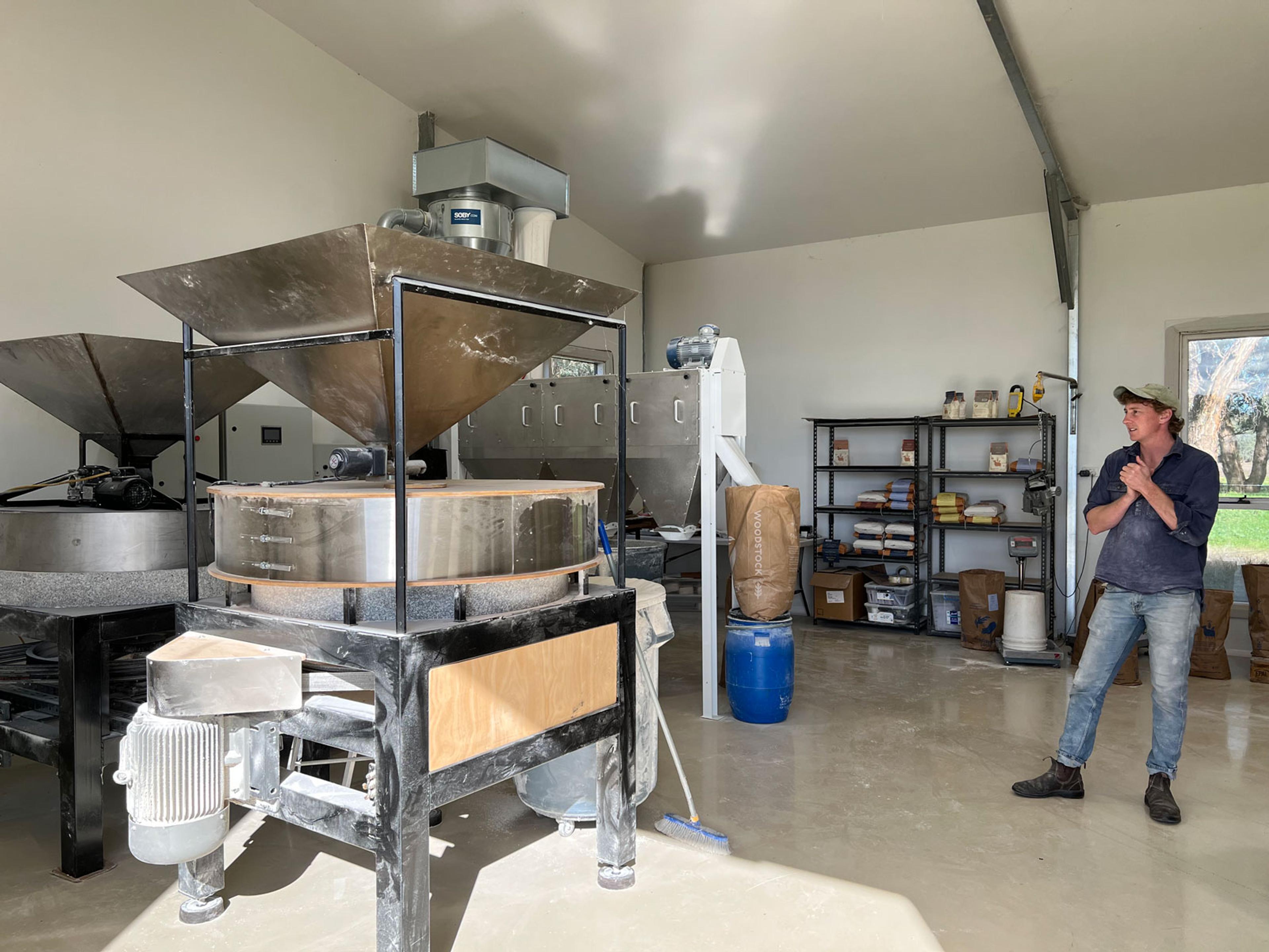 Ian is standing to the side and looking at the sifter.