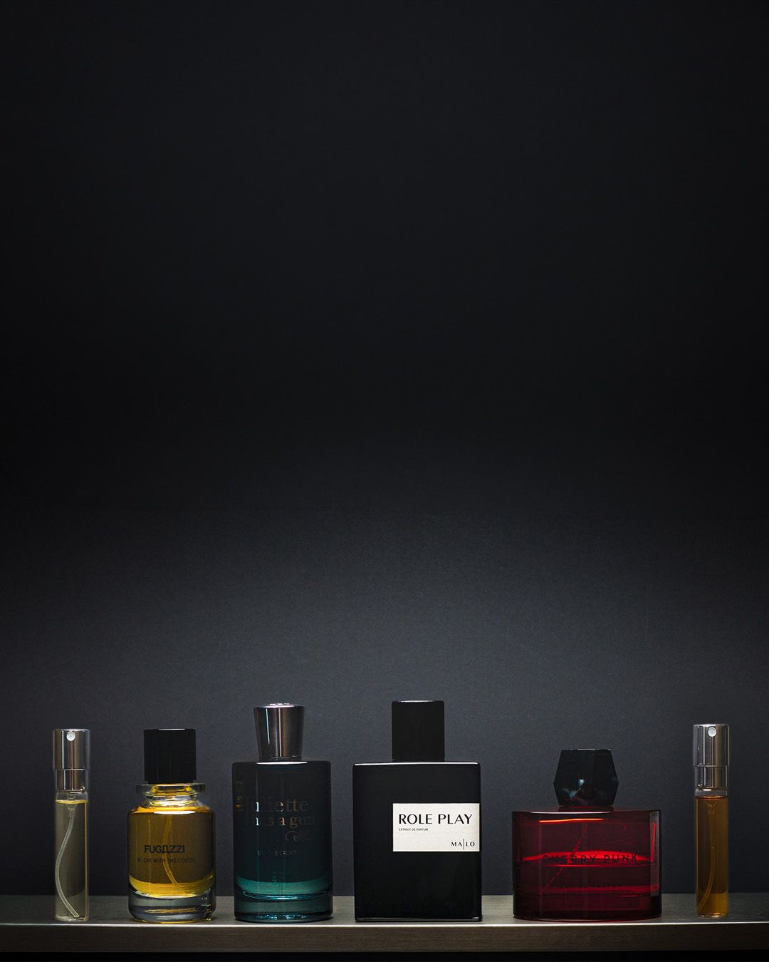 A numer of perfume bottles on a dark background.