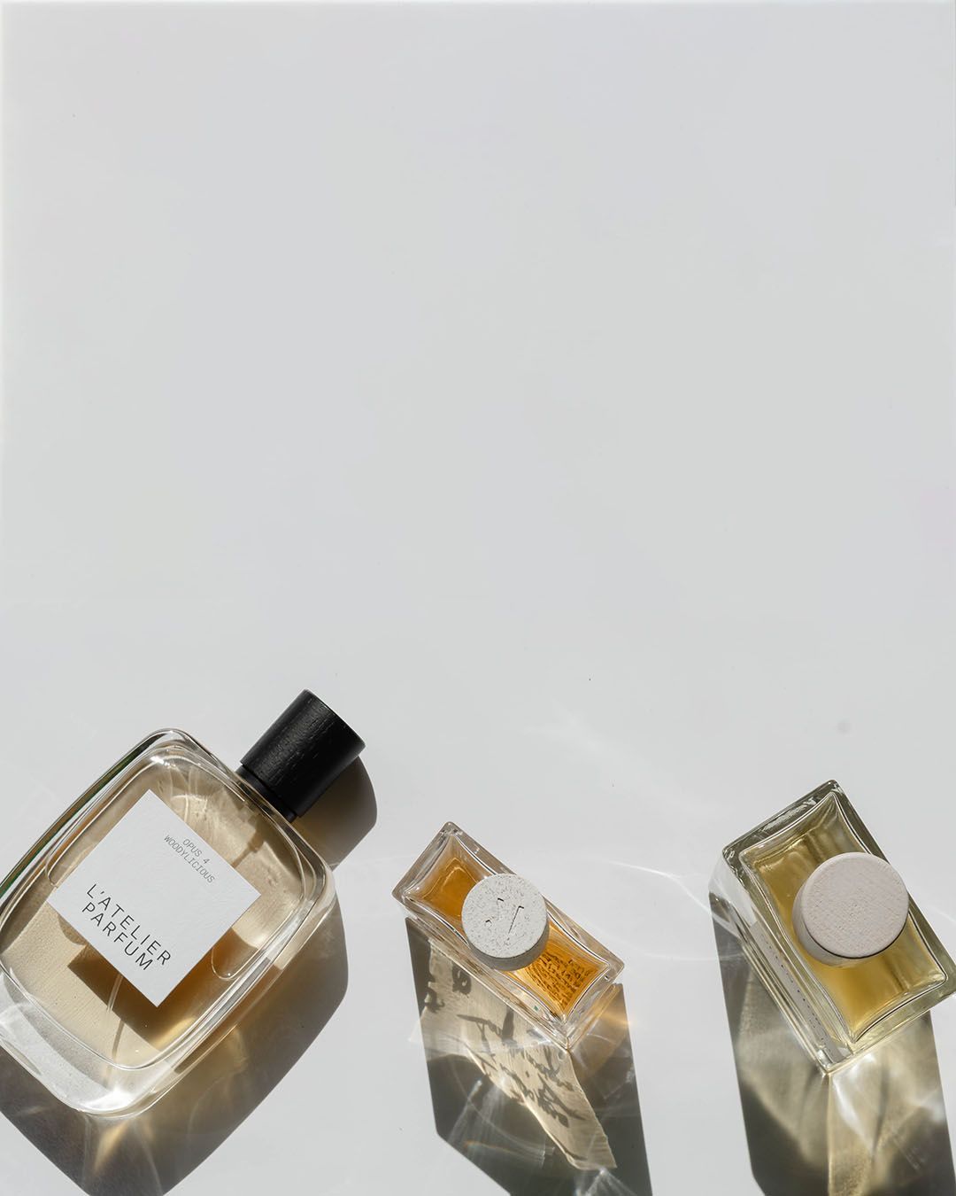 Fyra parfymflaskor mot en ljusgrå bakgrund