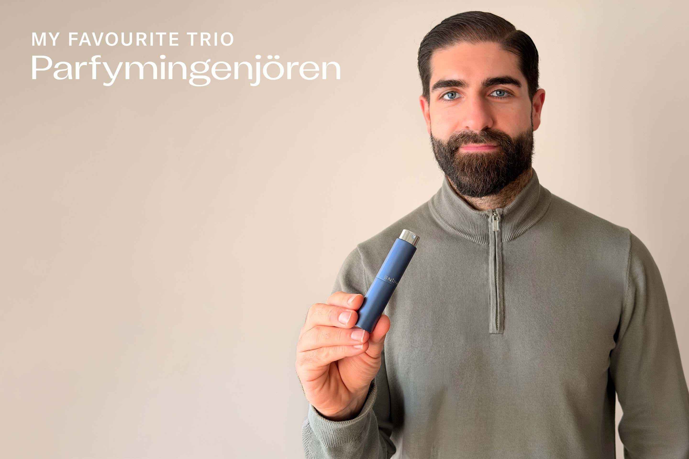 Serdar Coskun, står framför en ljus vägg. Han har mörkt hår, kort skägg, är klädd i en olivfärgad tröja och håller ett blått Sniph-etui med parfym i handen.