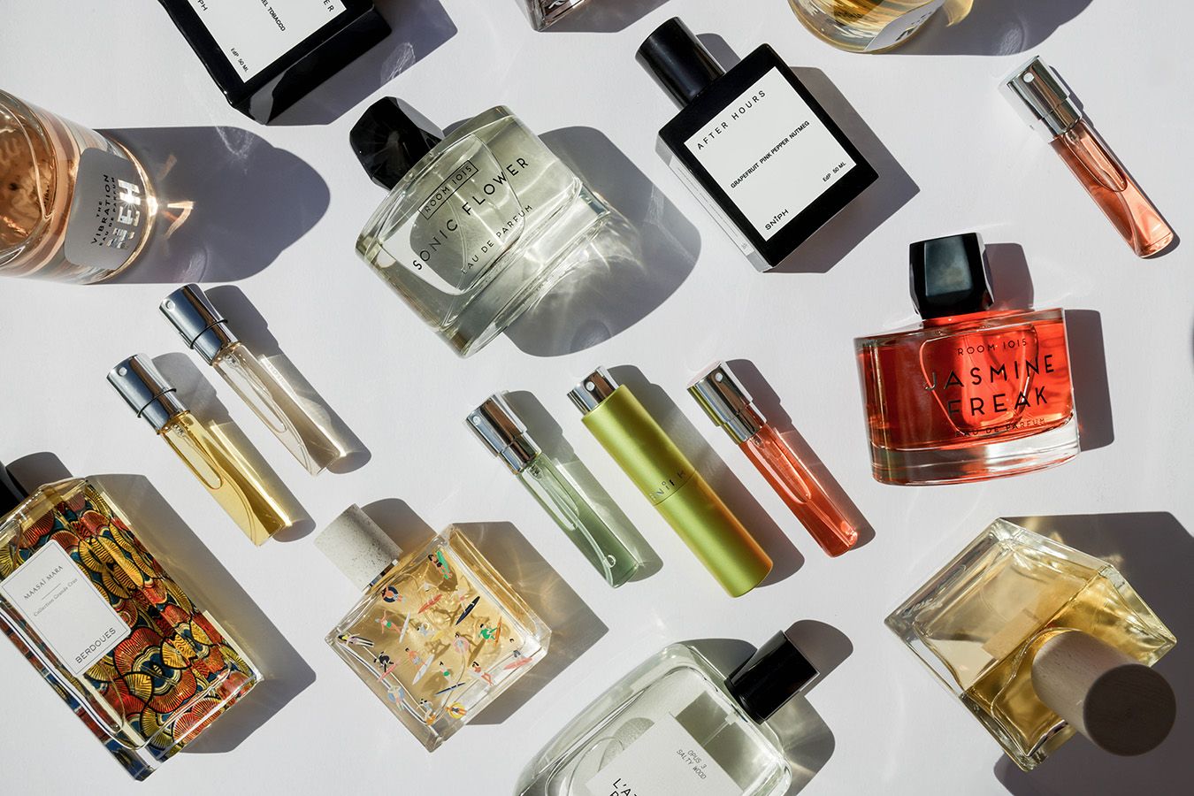 Perfume bottles of various sizes on a light background.