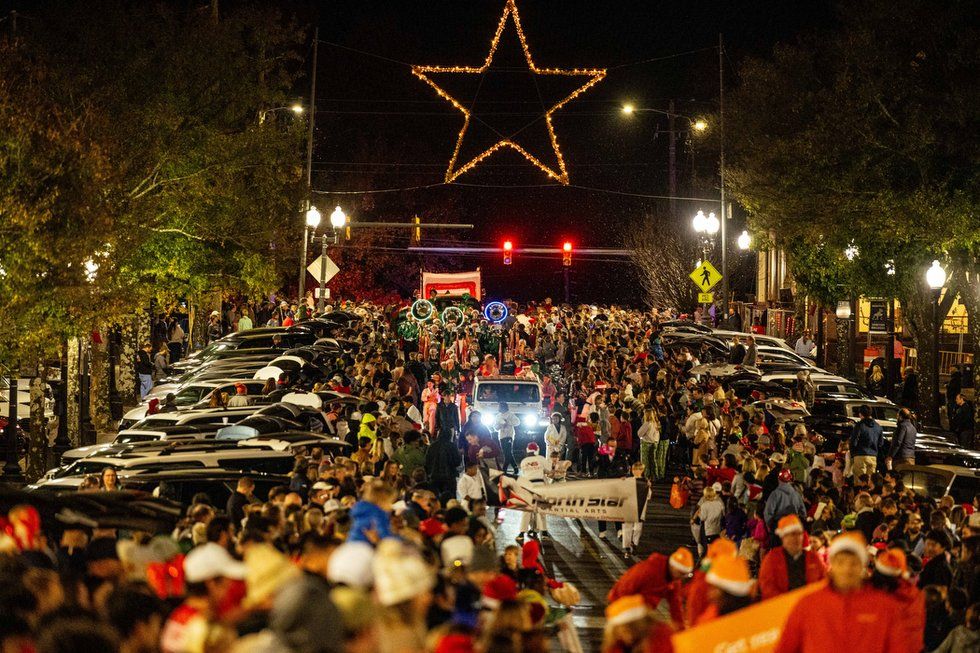 Crowds line the streets of downtown Homewood for the annual Christmas Parade, with the iconic illuminated star glowing above the intersection at night