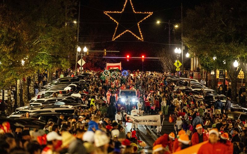 Crowds line the streets of downtown Homewood for the annual Christmas Parade, with the iconic illuminated star glowing above the intersection at night