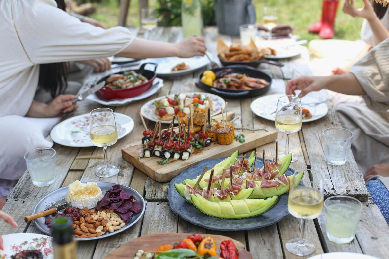 Friends gathered around an outdoor table for a backyard summer dinner, the kind of evening Birmingham was made for