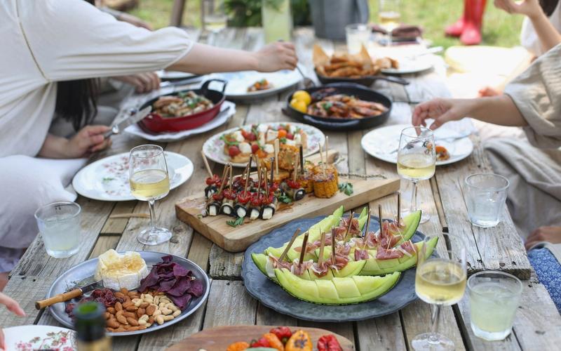 Friends gathered around an outdoor table for a backyard summer dinner, the kind of evening Birmingham was made for