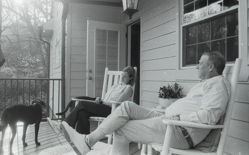 Couple on a residential porch resting with their dog, a warm portrait of established homeownership in Birmingham
