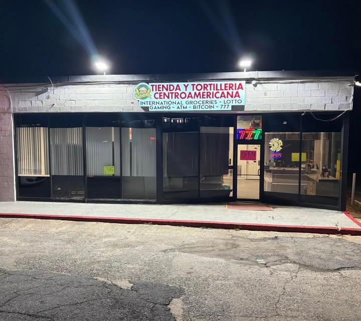 Fachada de Tienda y Tortillería Centroamericana de noche, con el letrero de la tienda iluminado