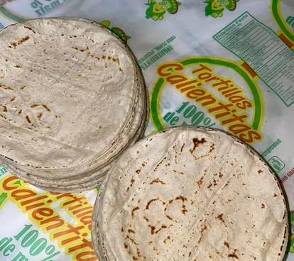 Pila de tortillas de maíz frescas envueltas en su empaque de Tortillas Calientitas