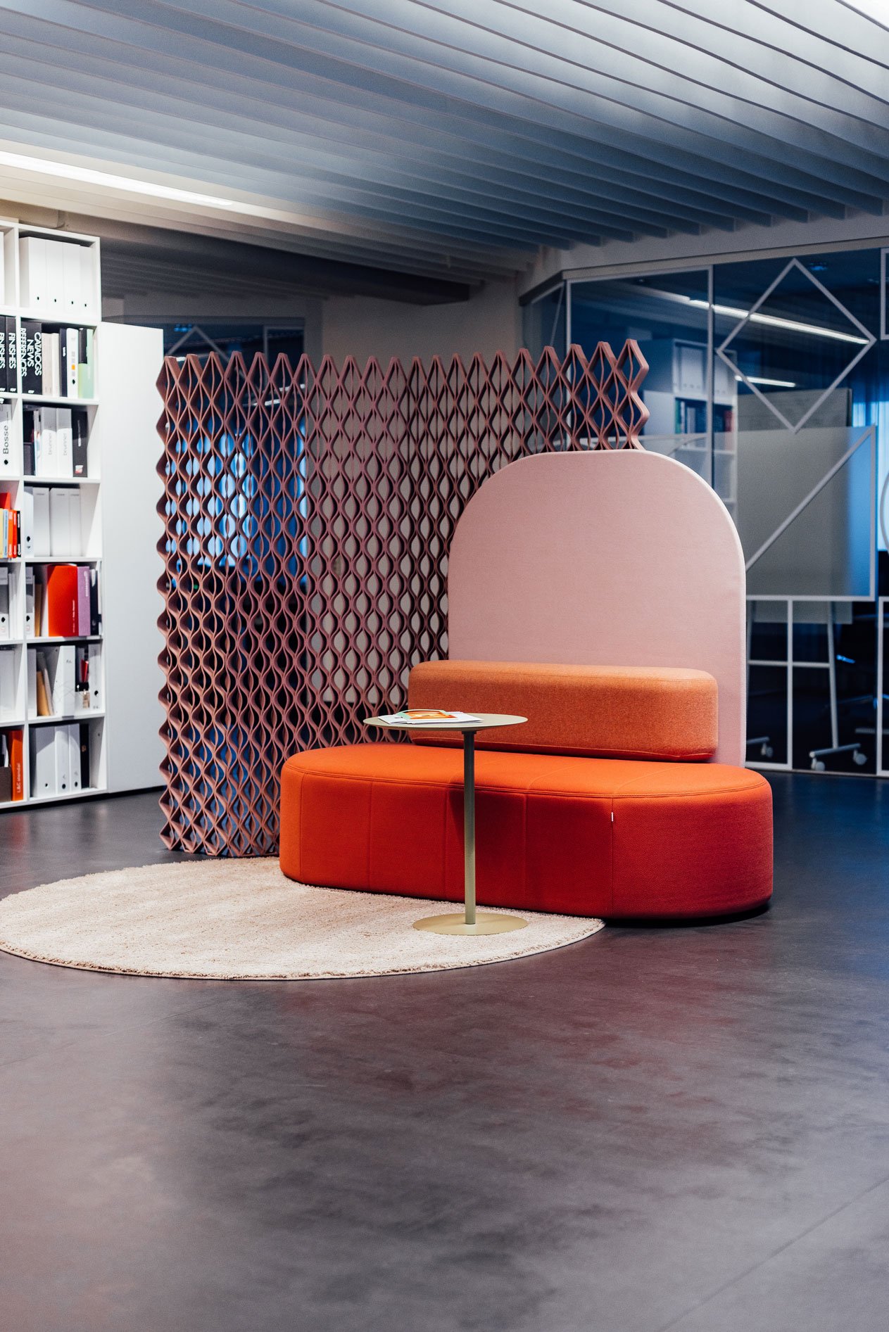 Orangenes Sofa mit beigem Beistelltisch in einem offenen Arbeitsbereich