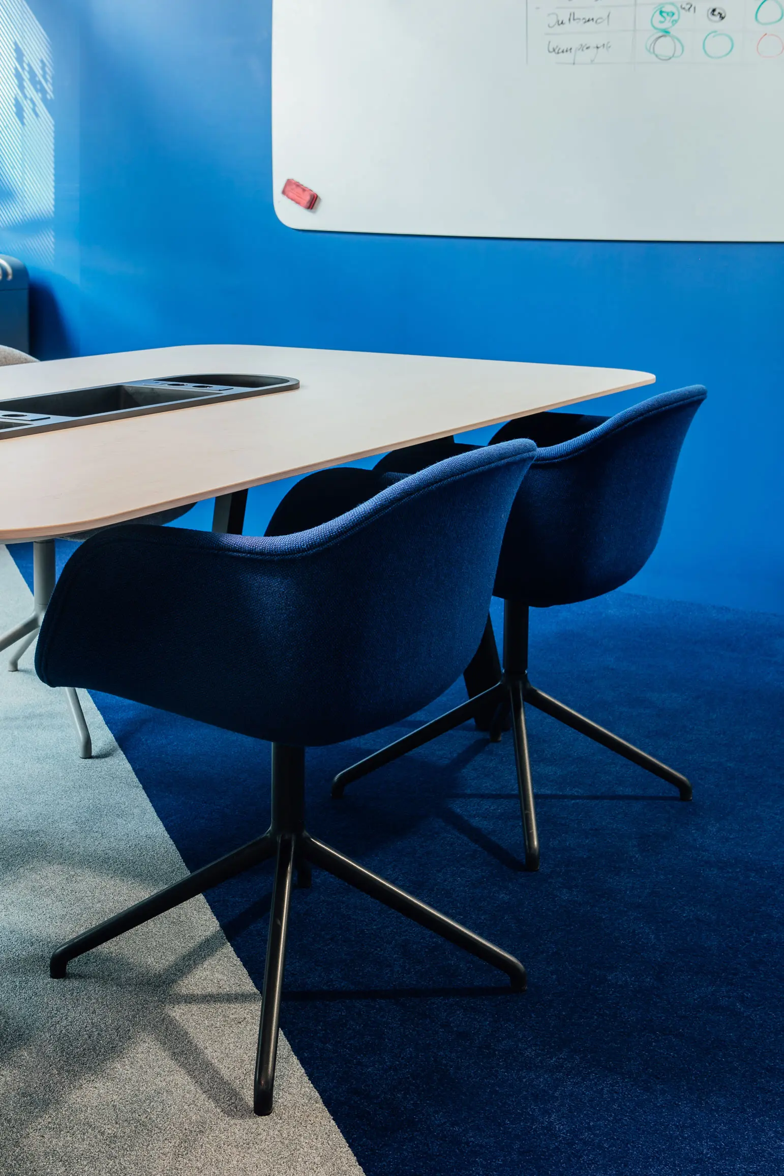 Meetingraum mit blauen Büromöbeln und Teppich