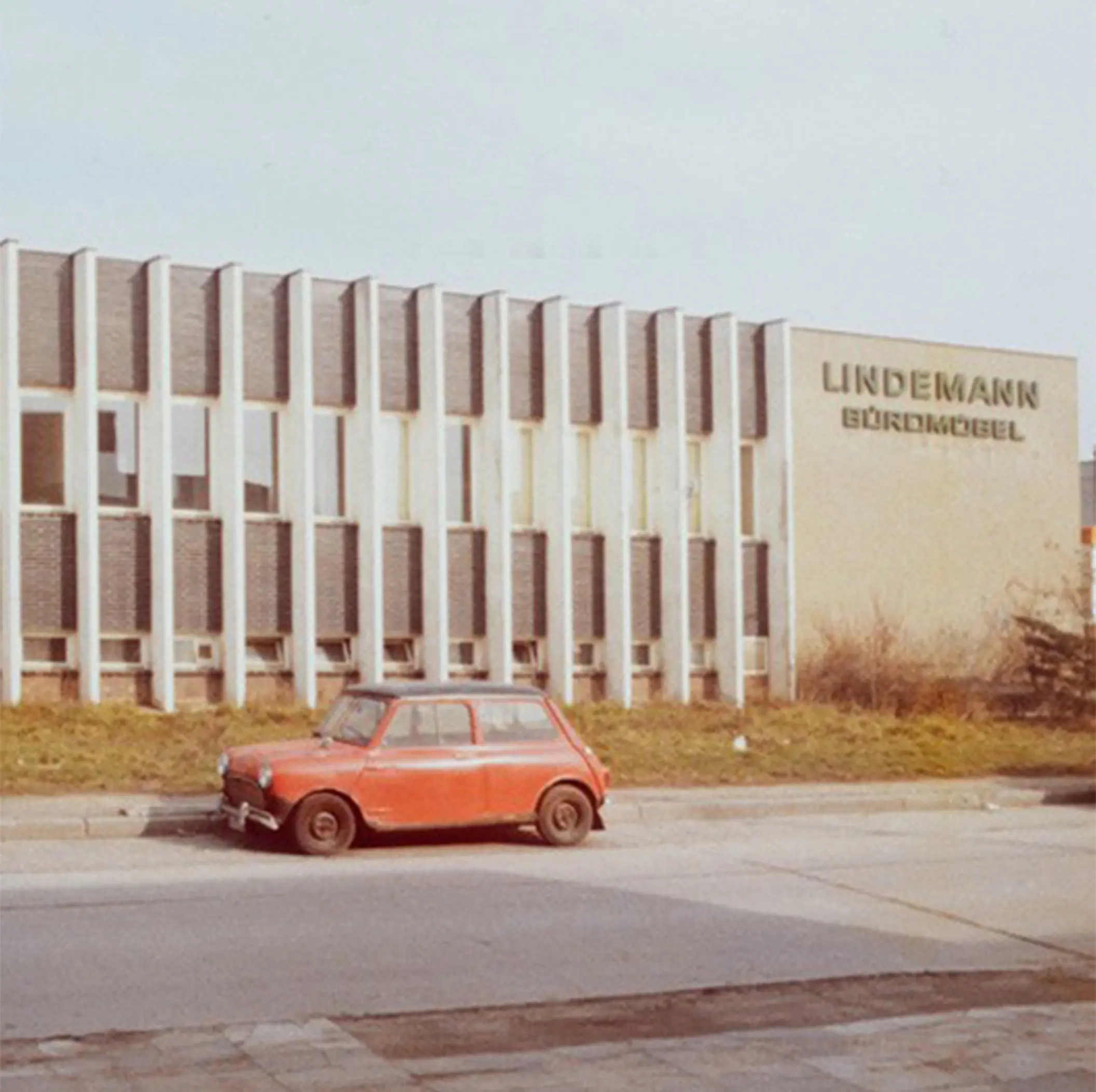 Historical image showing a car parked in front of the Lindemann office building