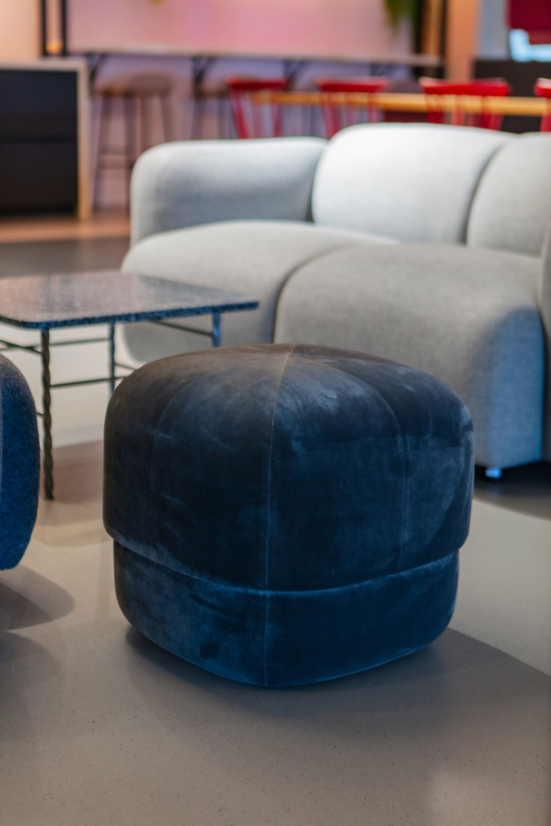 Sitzpouf vor grauer Couch mit Beistelltisch