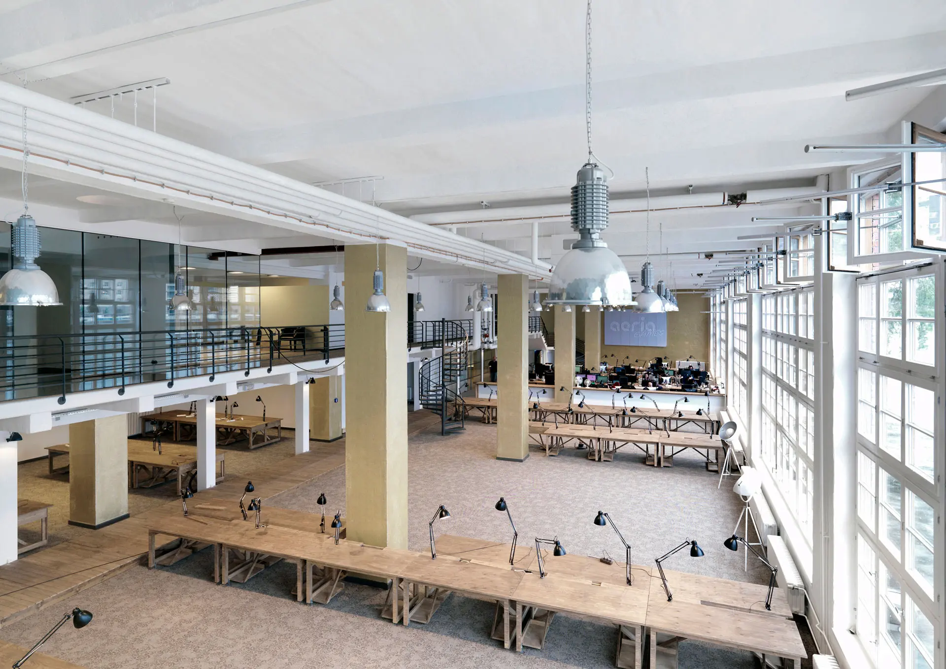 A photo of an office with wooden furniture and big windows in industrial style
