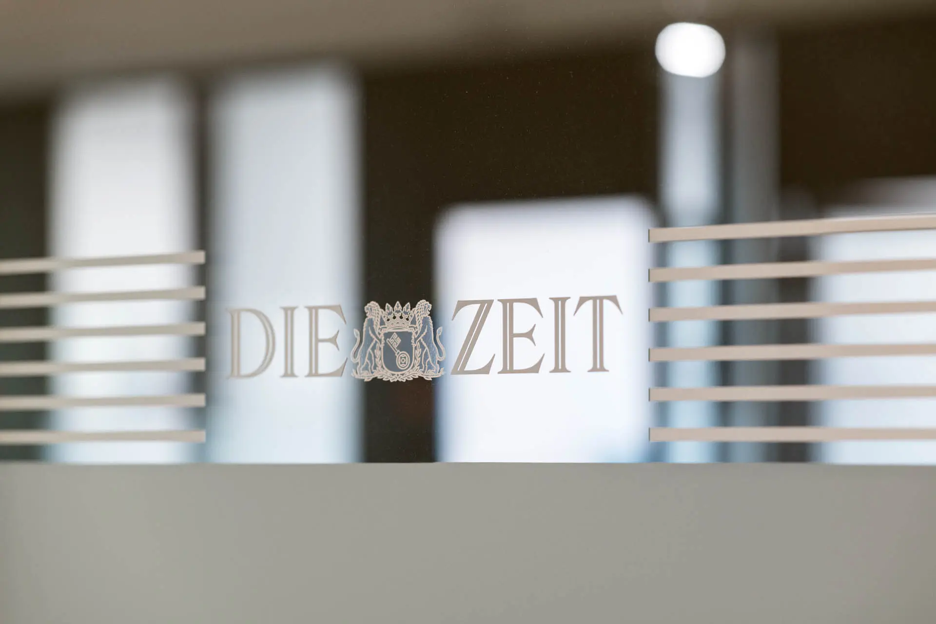 Bild vom DIE ZEIT Logo auf der Fensterscheibe im Eingangsbereich des Bürogebäudes