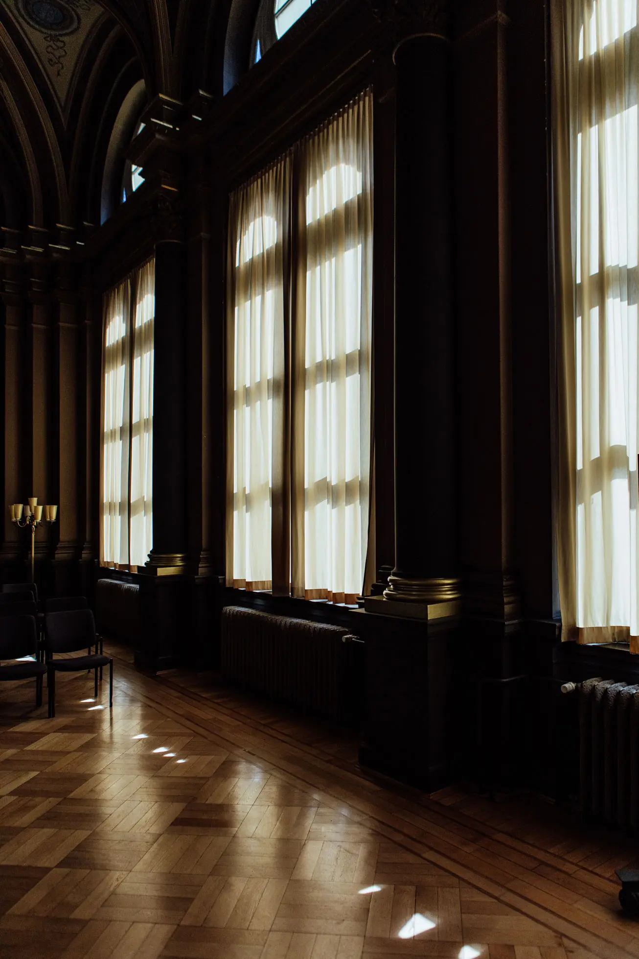 Image of an office space with wooden parquet and draped windows