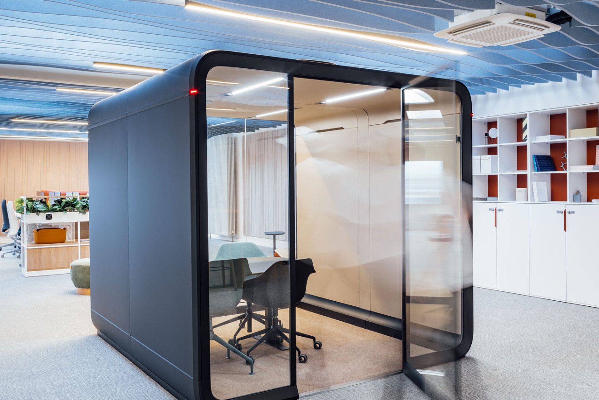 Blaue Framery Kabine im Open Space Bereich des Showrooms von LINDEMANN