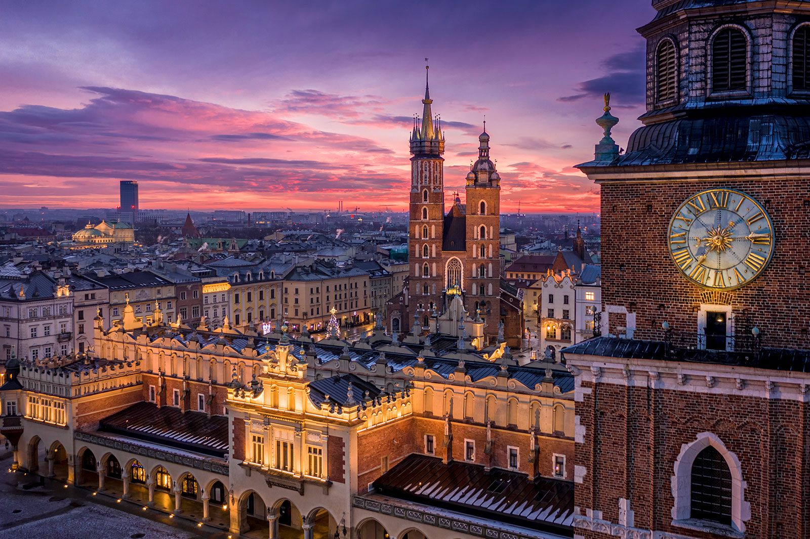 A sunset view over an old city with lights on buildings.