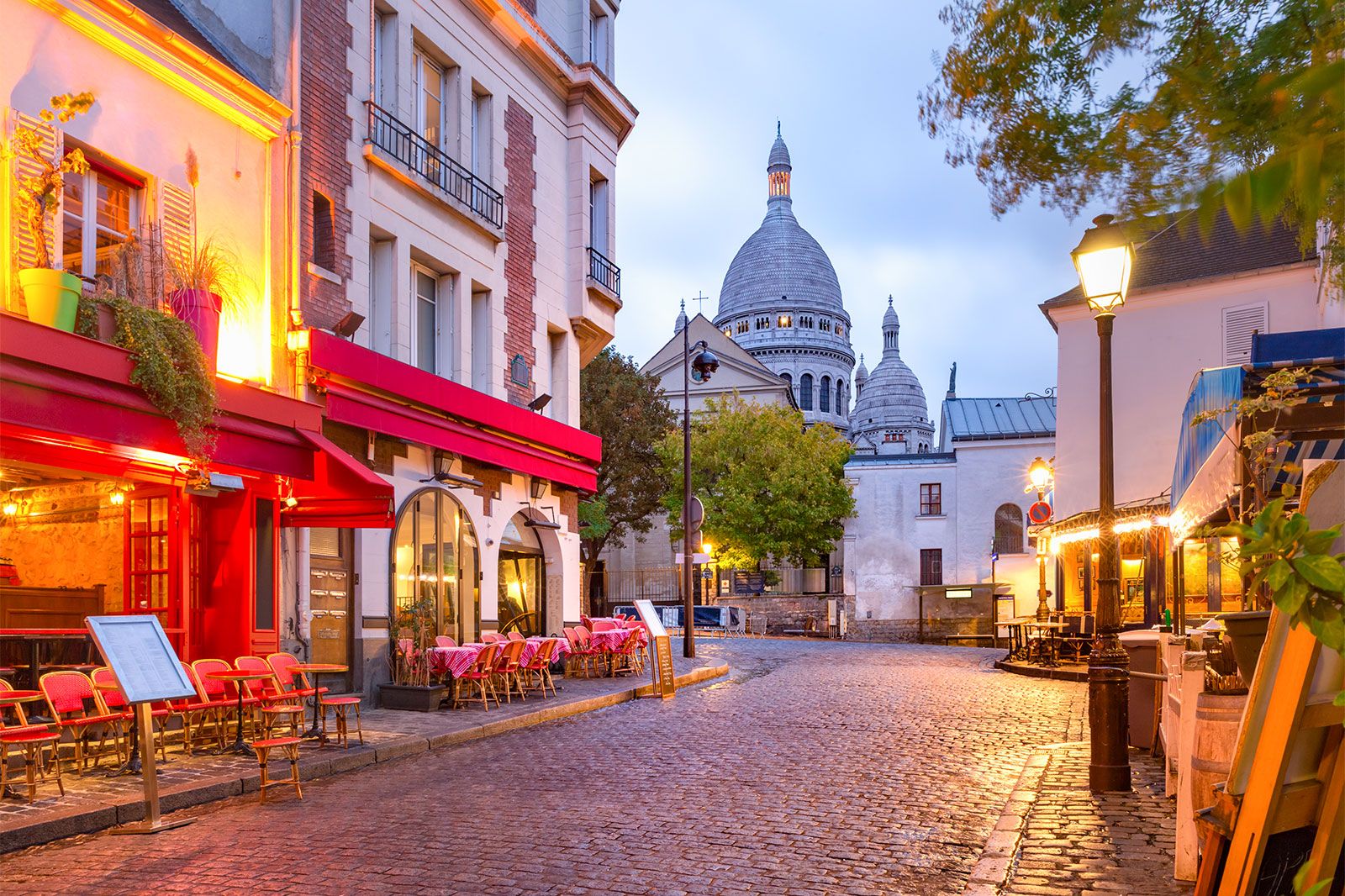 The Sacrecoeur Basilica between buildings in paris at night.