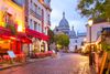 The Sacrecoeur Basilica between buildings in paris at night.