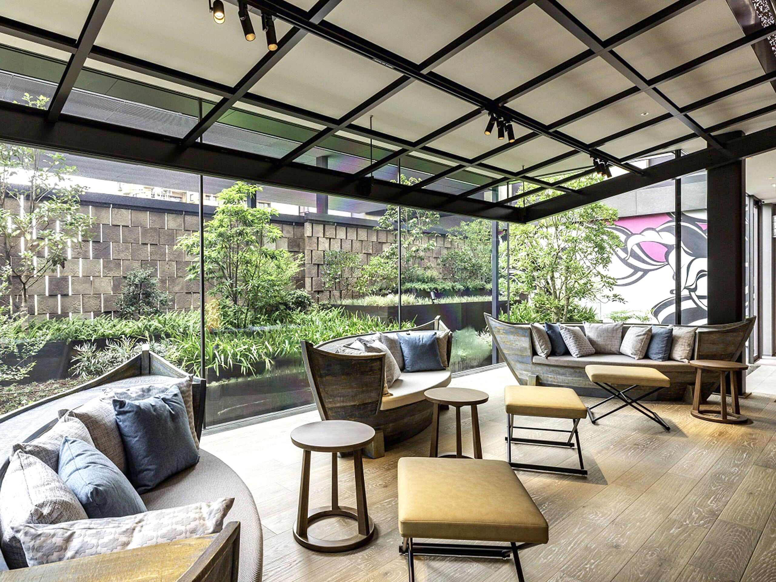 Lobby with wall of windows and chairs, tables and sofas with throw pillows.